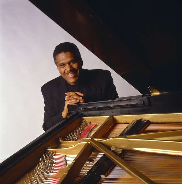 Donal Fox looks over the the interior of a piano.